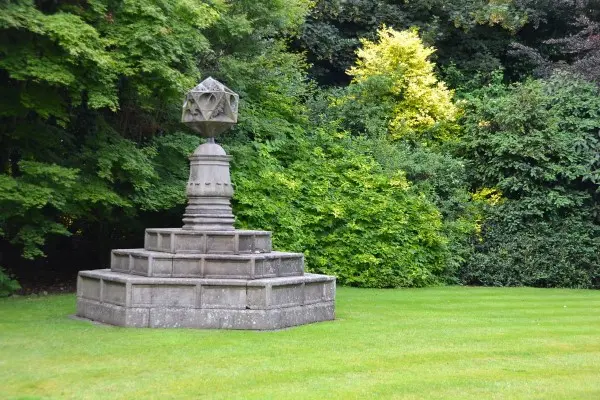 Elegant Victorian fountain surrounded by manicured lawns and floral displays at the Palace of Holyroodhouse gardens.